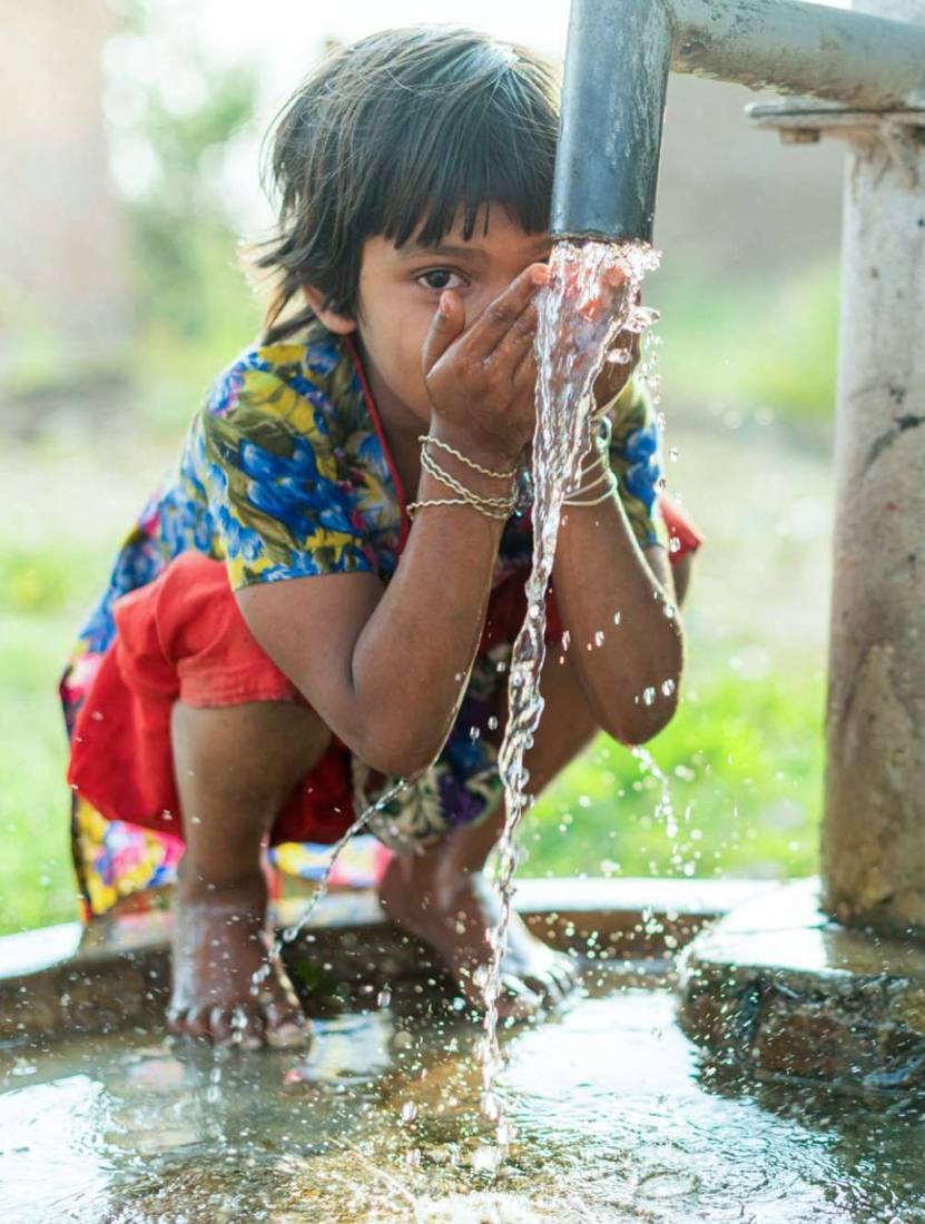 A child drinking water from a tap